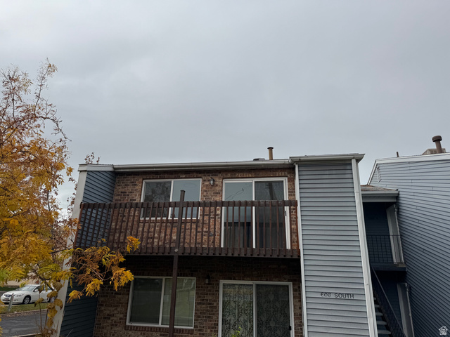 608 South 500 West, Unit 3 Provo, UT 84601 - Photo 2 of 35 Exterior facade featuring brick and horizontal siding, an upper-level balcony with wood railing, and ground-level windows