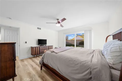 a bedroom with a bed a flat screen tv and dresser