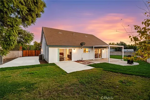 a front view of a house with a garden and trees