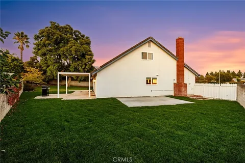 a view of backyard with barbeque grill and wooden fence