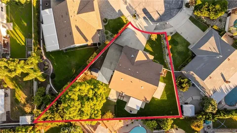 an aerial view of residential houses with outdoor space and trees