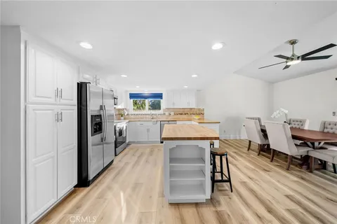 a kitchen with granite countertop white cabinets and stainless steel appliances