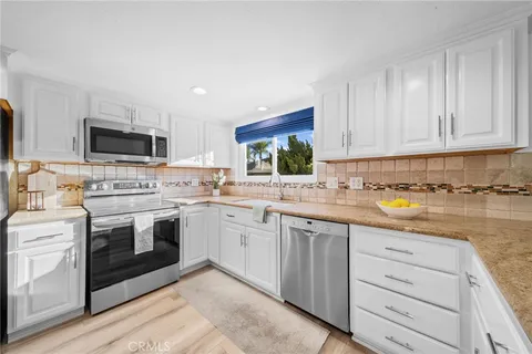 a very nice looking kitchen with a stove a kitchen island a sink and a refrigerator