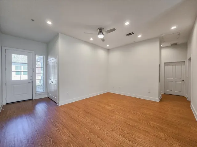 an empty room with wooden floor and windows
