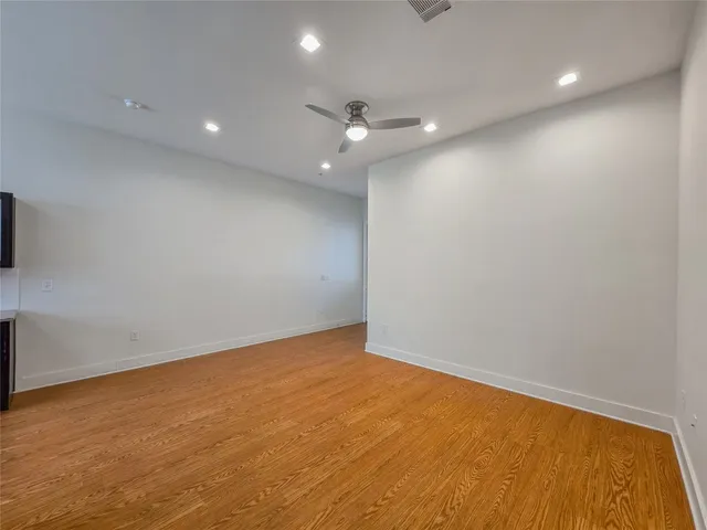 an empty room with a ceiling fan and window