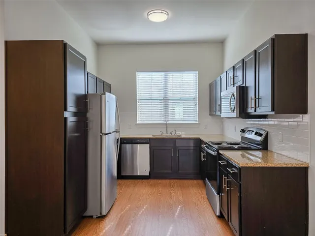 a kitchen with stainless steel appliances granite countertop a refrigerator stove and sink