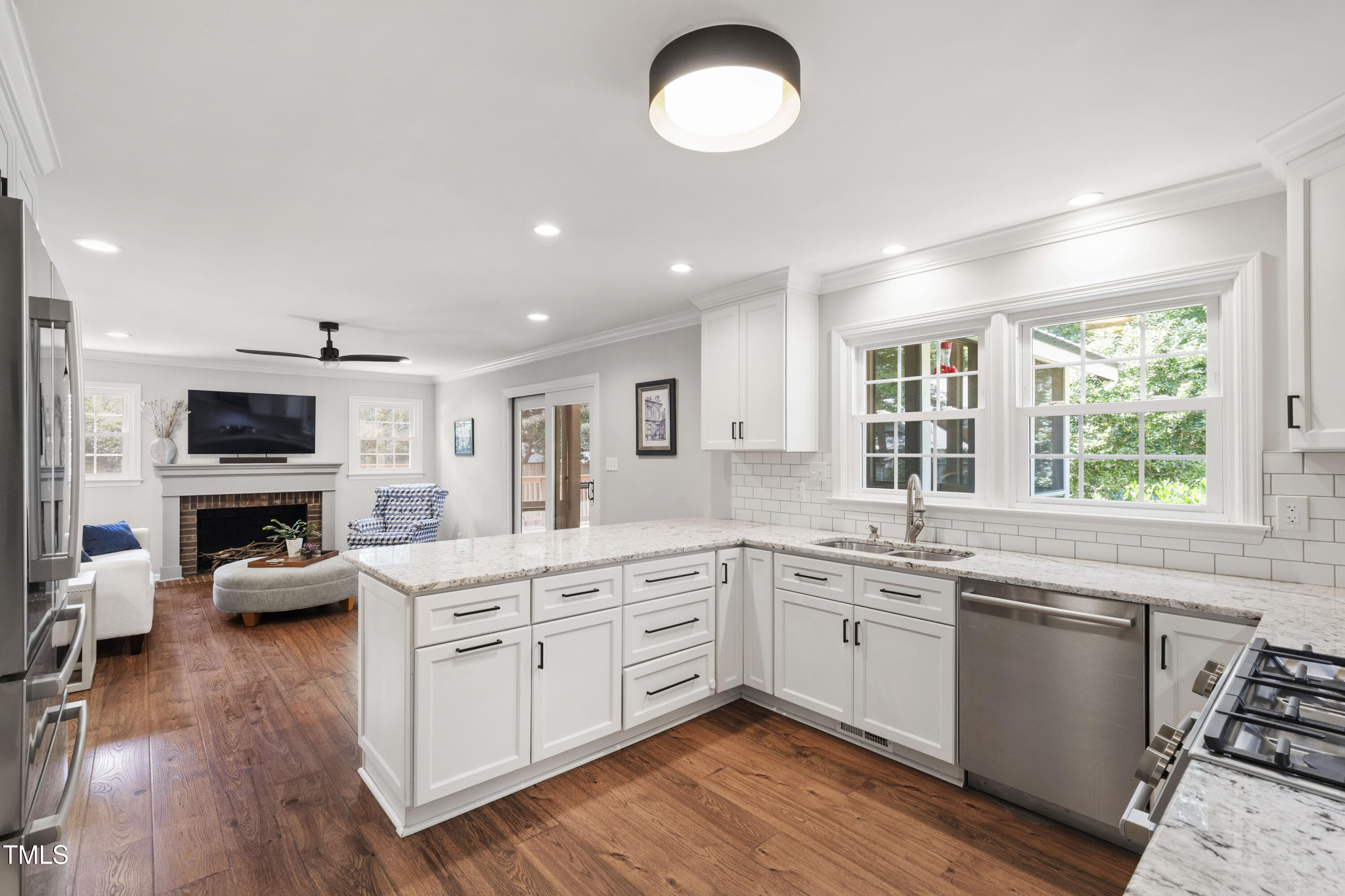 3209 Caldwell Drive Raleigh, NC 27607 - Photo 15 of 42 a kitchen with stainless steel appliances granite countertop a stove top oven a sink dishwasher and white cabinets with wooden floor