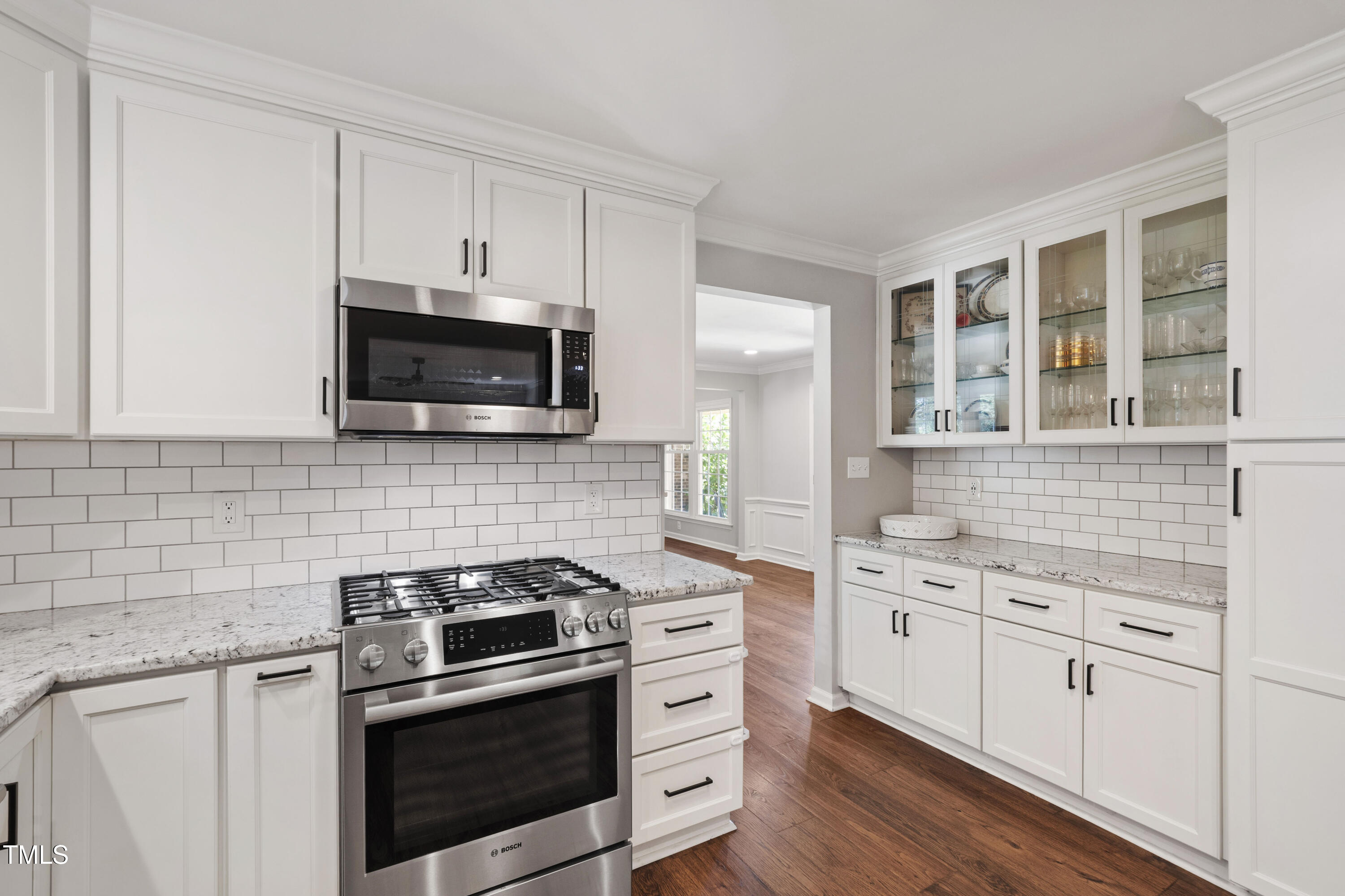 3209 Caldwell Drive Raleigh, NC 27607 - Photo 19 of 42 a kitchen with cabinets stainless steel appliances and wooden floor