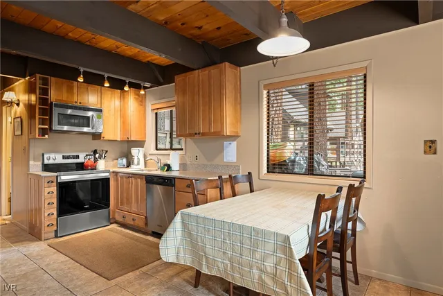 a kitchen with stainless steel appliances granite countertop a stove a sink dishwasher and a microwave oven with cabinets