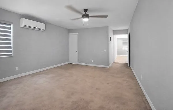 an empty room with a ceiling fan and a window