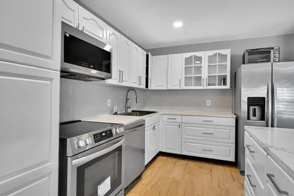 a kitchen with stainless steel appliances granite countertop a stove microwave and sink
