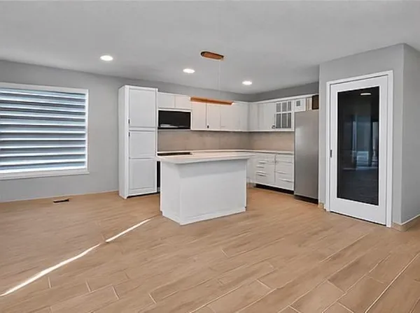 a view of kitchen with wooden floor and electronic appliances