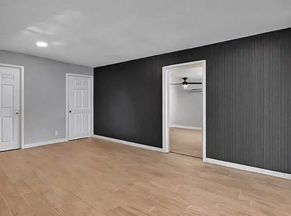 a view of an empty room with wooden floor
