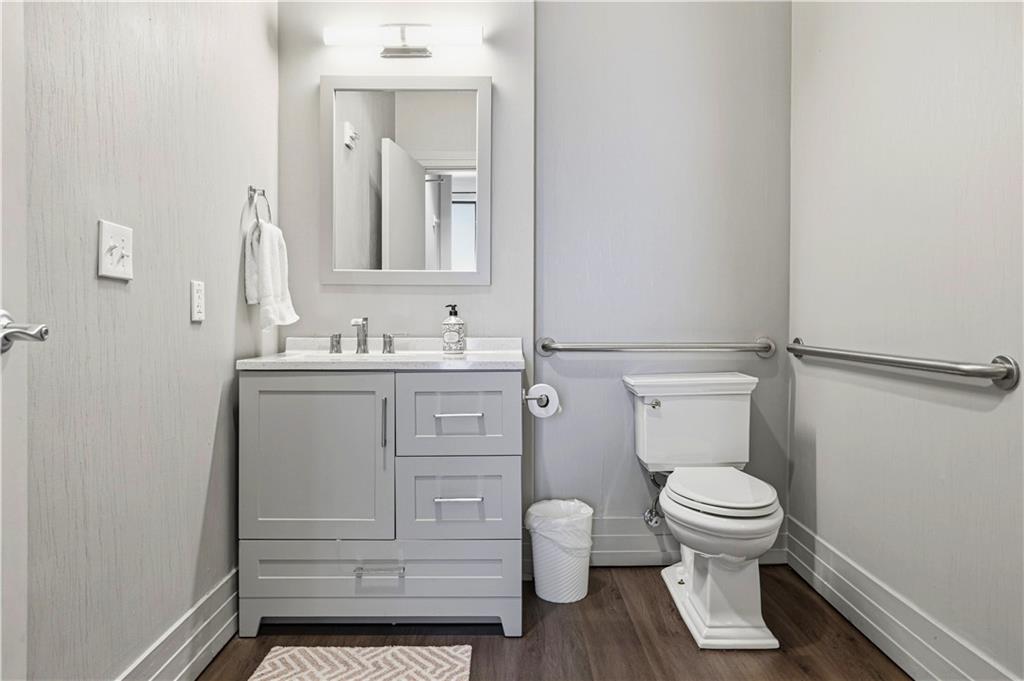 3040 Peachtree Road Northwest, Unit 1503 Atlanta, GA 30305 - Photo 37 of 38 a bathroom with a toilet sink vanity and mirror