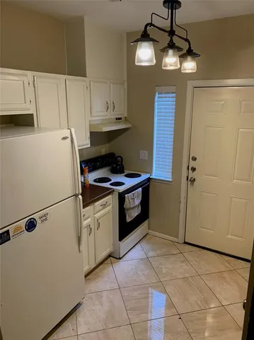 a kitchen with stainless steel appliances granite countertop a refrigerator a sink dishwasher and a stove with white cabinets