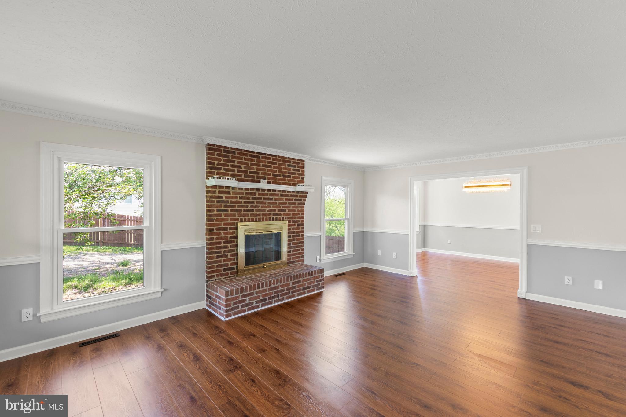 405 Spring Hollow Road Woodstock, VA 22664 - Photo 22 of 98 an empty room with wooden floor fireplace and windows