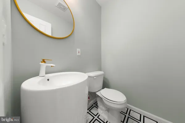 a living room with a black white checkered floor with couches chair and a coffee table
