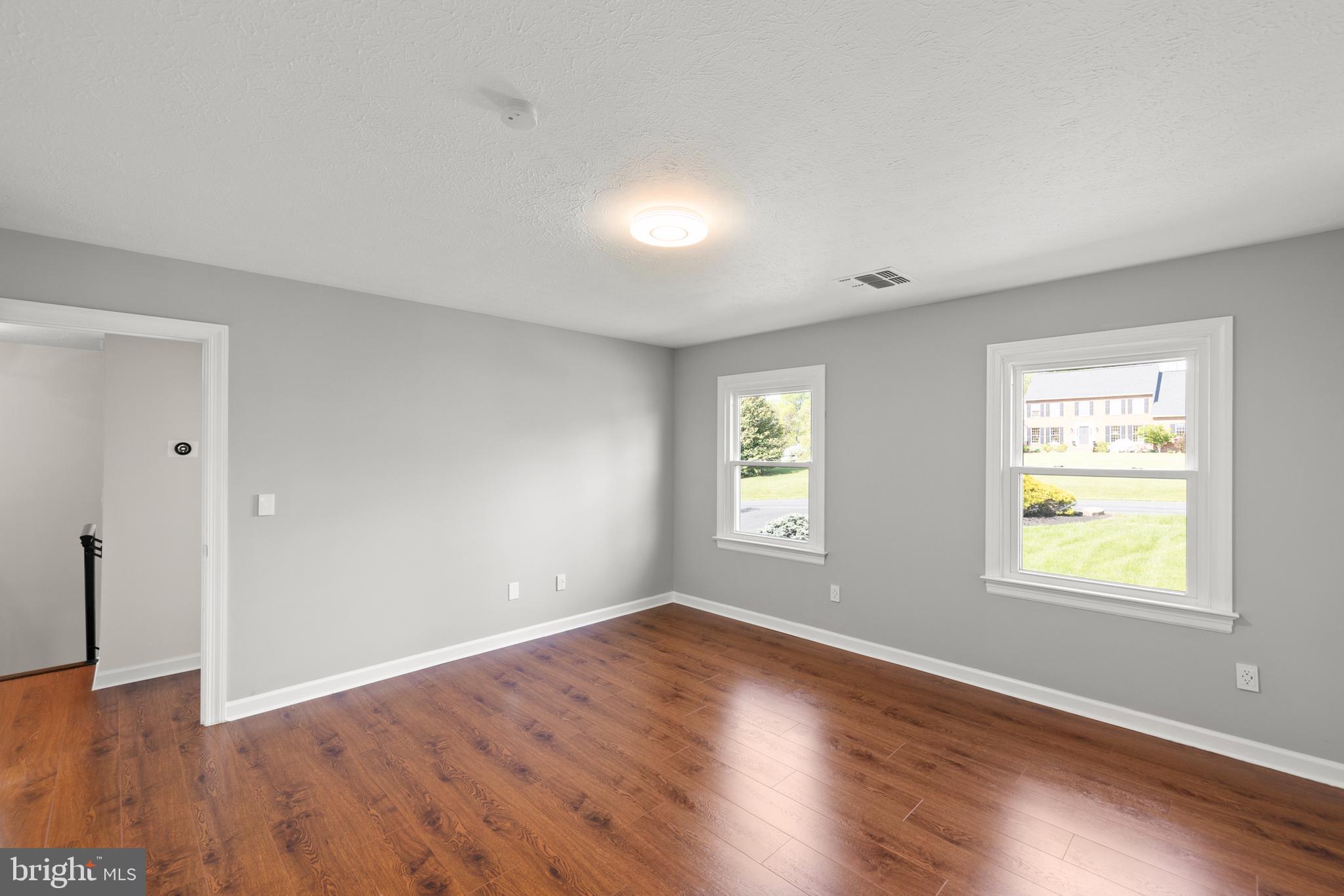 405 Spring Hollow Road Woodstock, VA 22664 - Photo 50 of 98 an empty room with wooden floor and windows