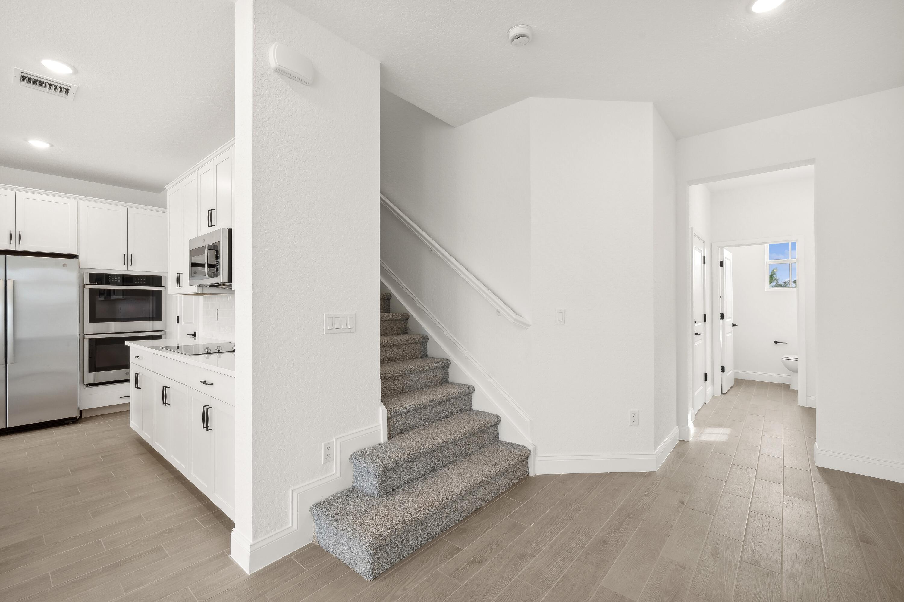 171 Southeast Birch Terrace, Unit 740 Stuart, FL 34997 - Photo 12 of 30 a view of a kitchen with wooden floor and electronic appliances