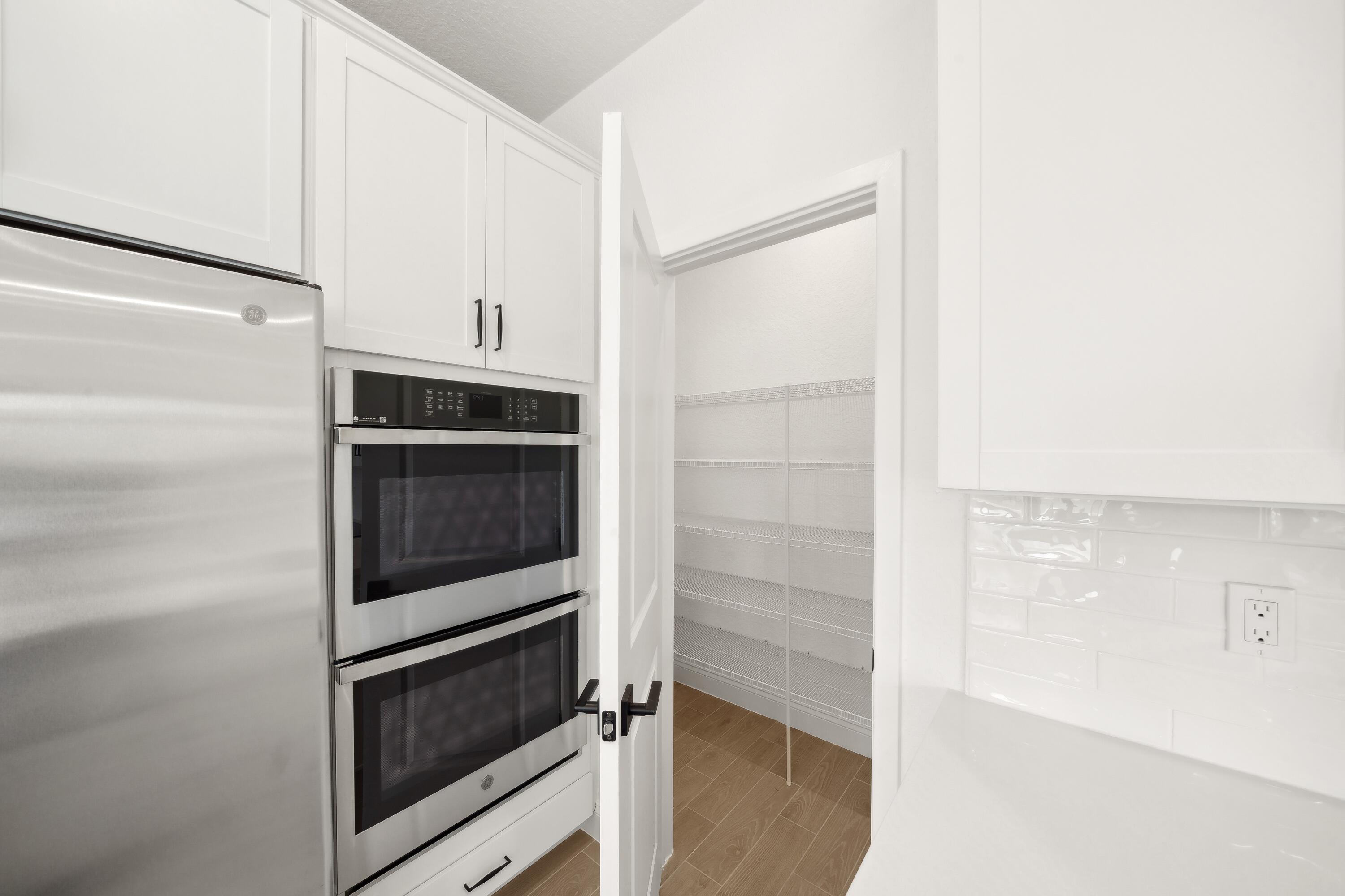 171 Southeast Birch Terrace, Unit 740 Stuart, FL 34997 - Photo 6 of 30 a kitchen with white cabinets and stainless steel appliances