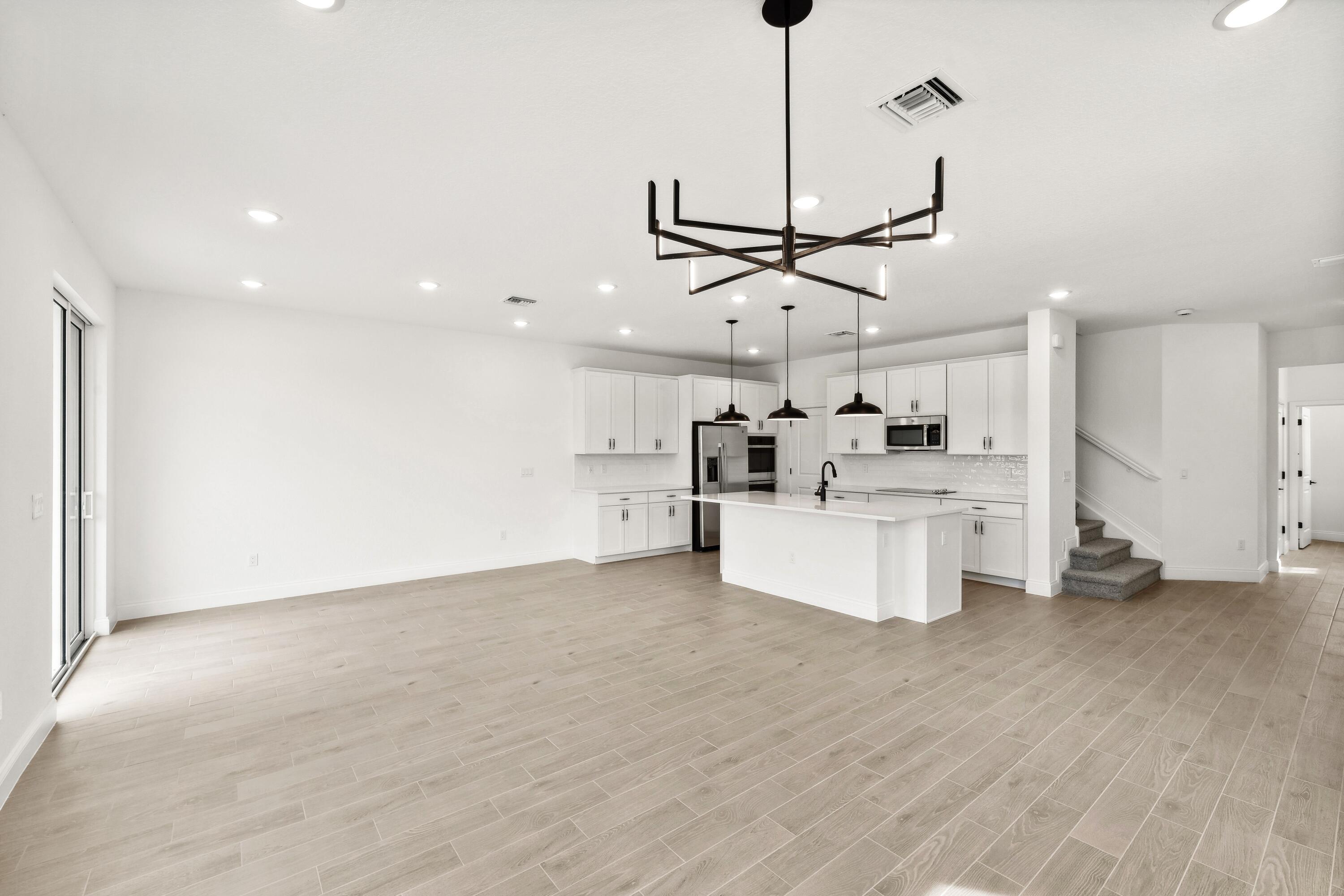 171 Southeast Birch Terrace, Unit 740 Stuart, FL 34997 - Photo 9 of 30 a view of a kitchen with a sink stainless steel appliances and a floor