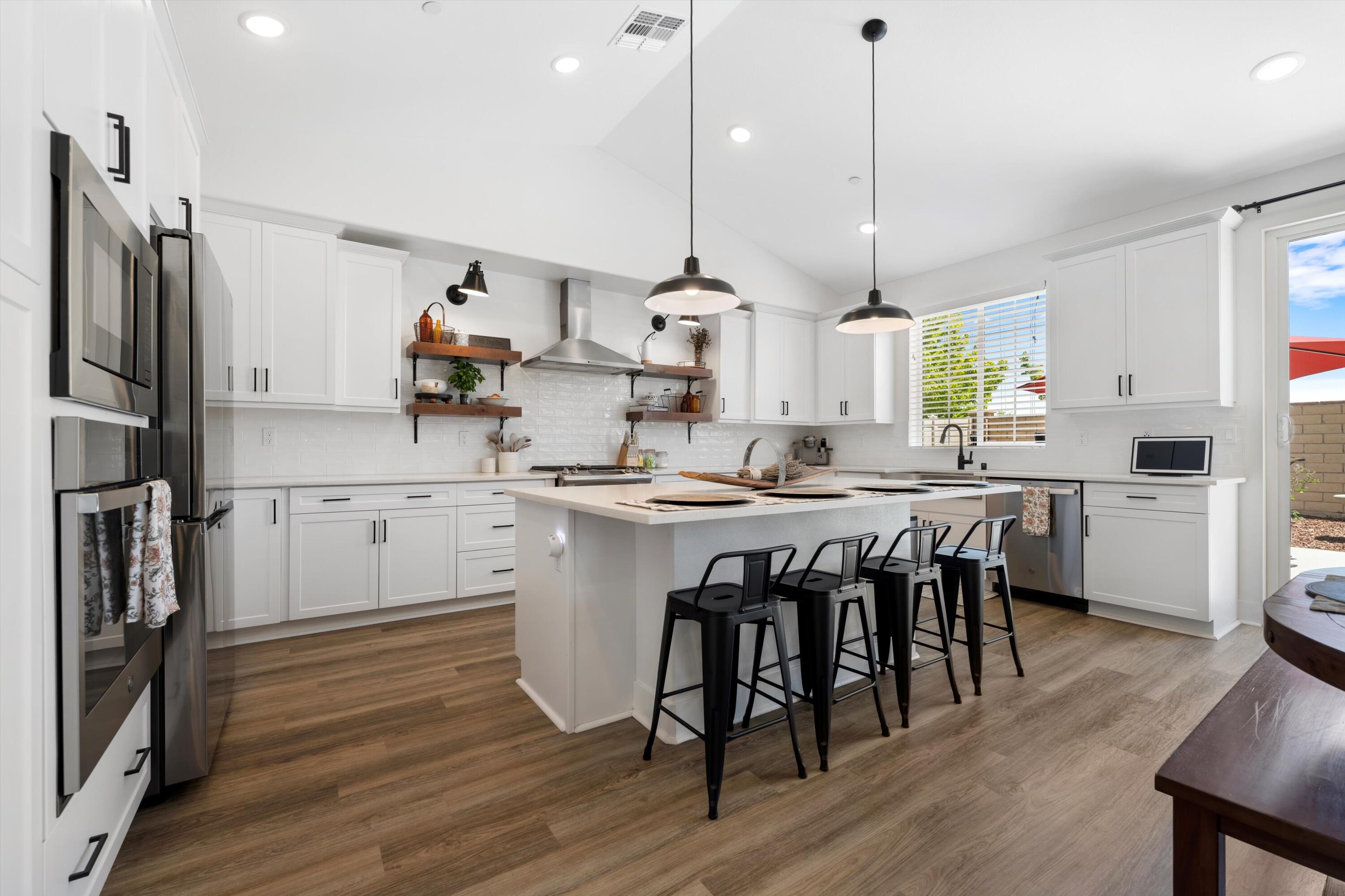 1344 Bodega Drive Tehachapi, CA 93561 - Photo 16 of 34 a kitchen with kitchen island stainless steel appliances a table chairs sink and wooden floor