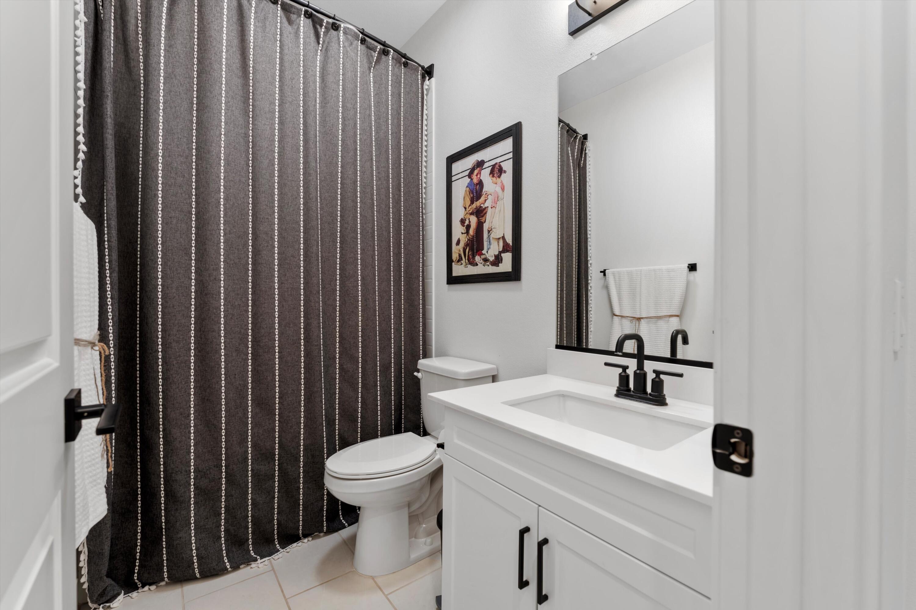 1344 Bodega Drive Tehachapi, CA 93561 - Photo 28 of 34 a bathroom with a sink a toilet and shower curtain