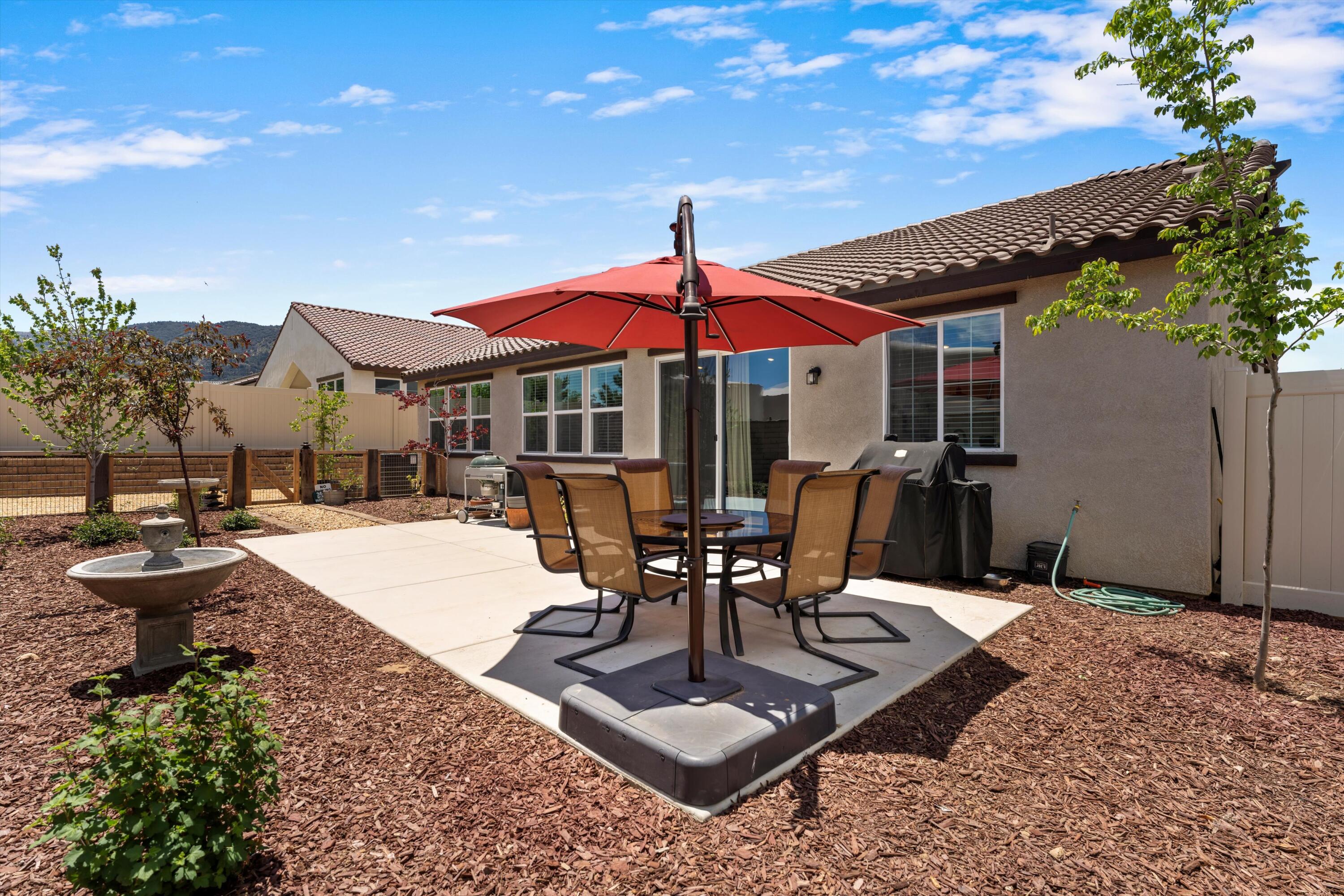 1344 Bodega Drive Tehachapi, CA 93561 - Photo 34 of 34 a view of a patio with a table and chairs under an umbrella