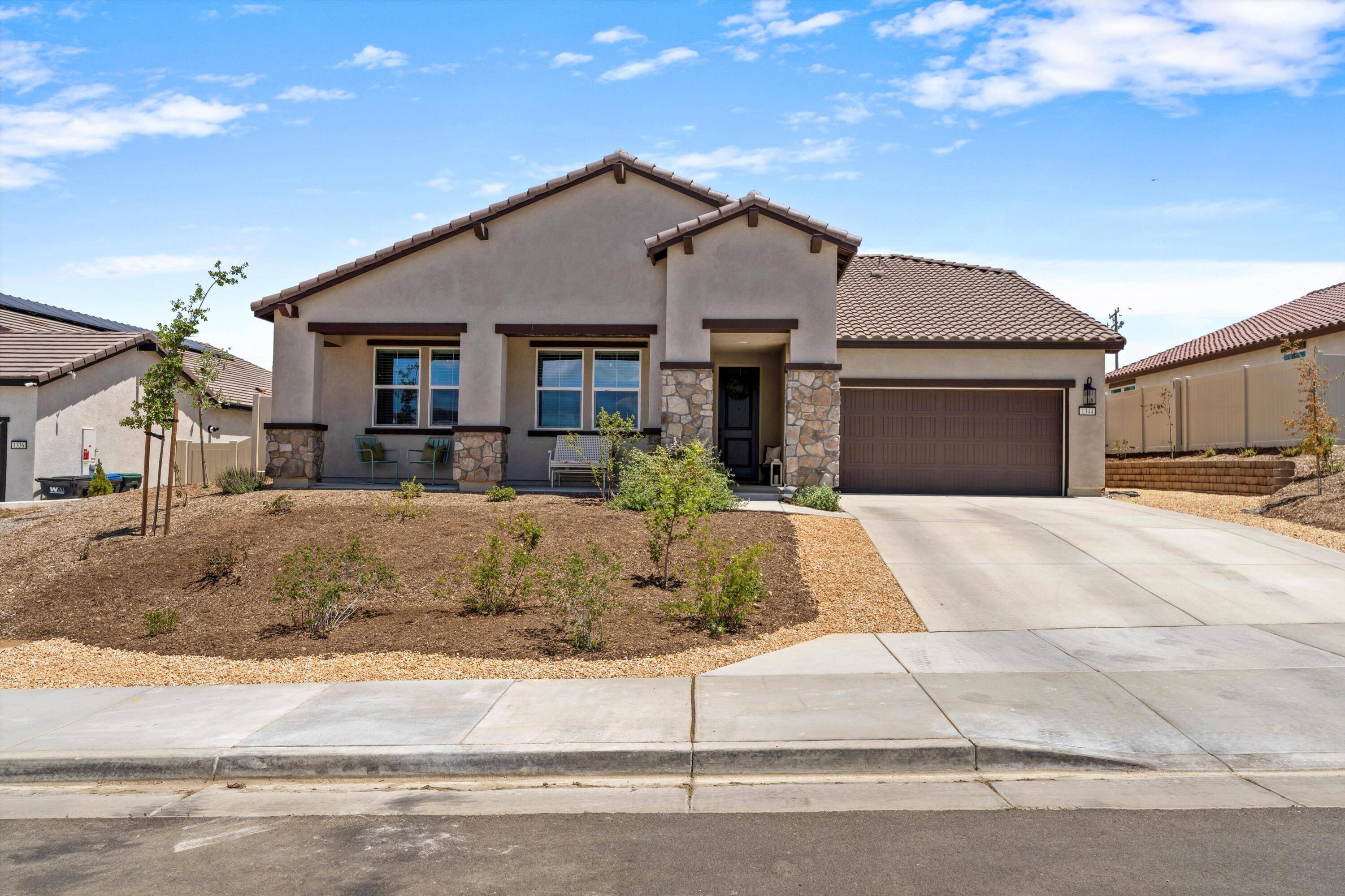 1344 Bodega Drive Tehachapi, CA 93561 - Photo 4 of 34 a front view of a house with a yard and garage