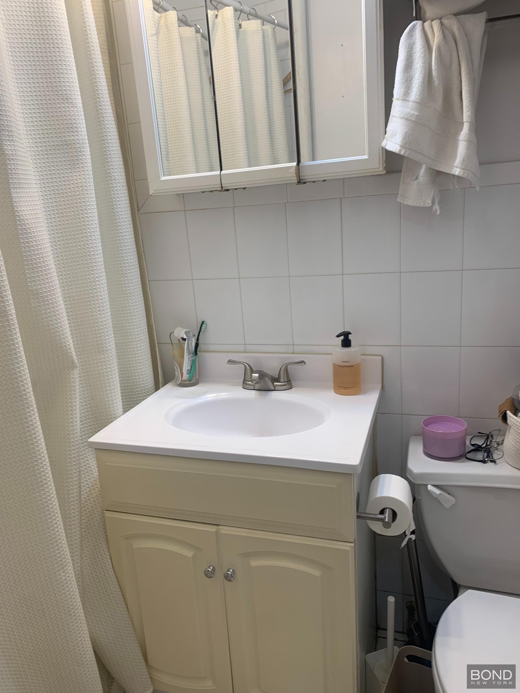 22 East 22nd Street, Unit 5C Manhattan, NY 10010 - Photo 5 of 5 a bathroom with a sink a toilet and vanity