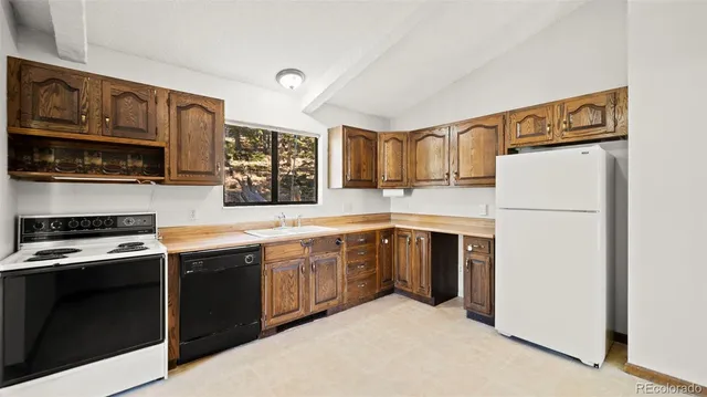 a large kitchen with stainless steel appliances granite countertop a stove and a sink