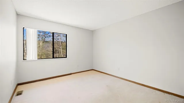 a view of a house with a yard and large tree