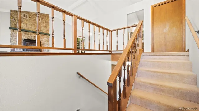 a view of an empty room with wooden floor and windows
