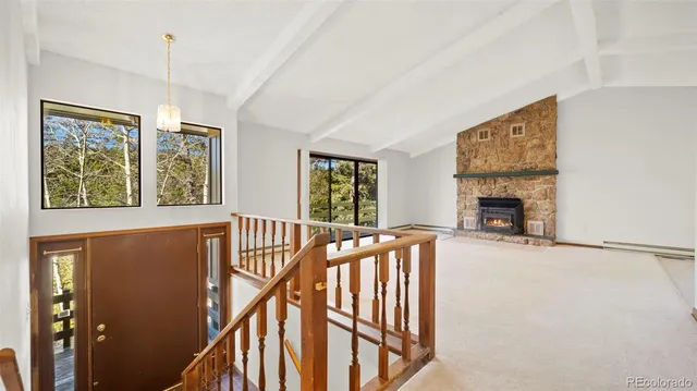 a view of an empty room with a fireplace and a window
