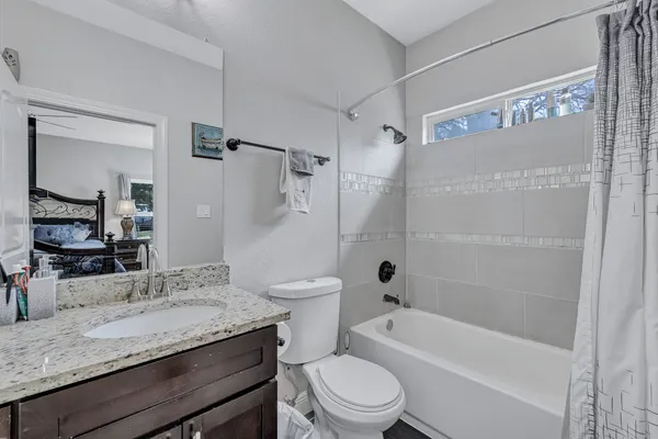 a bathroom with a granite countertop toilet sink and bathtub
