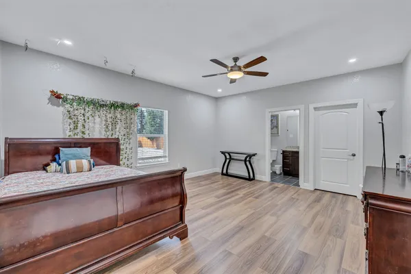 a bedroom with a bed and a ceiling fan