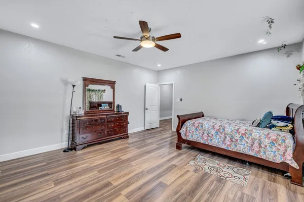 a bedroom with a bed and wooden floor