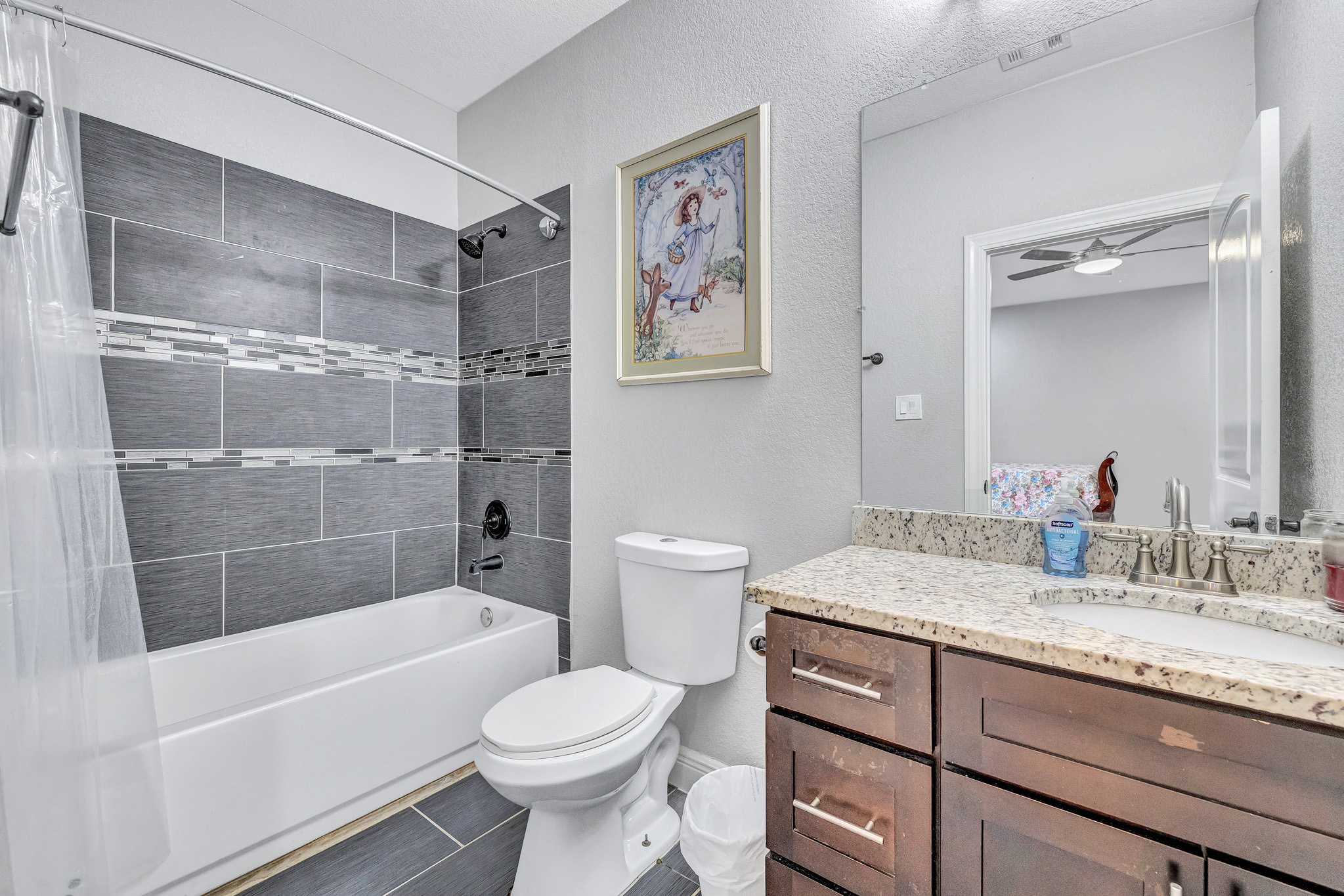 421 Las Lomas Drive Elgin, TX 78621 - Photo 17 of 30 Bathroom with vanity, a textured wall, shower / tub combo with curtain, and ceiling fan