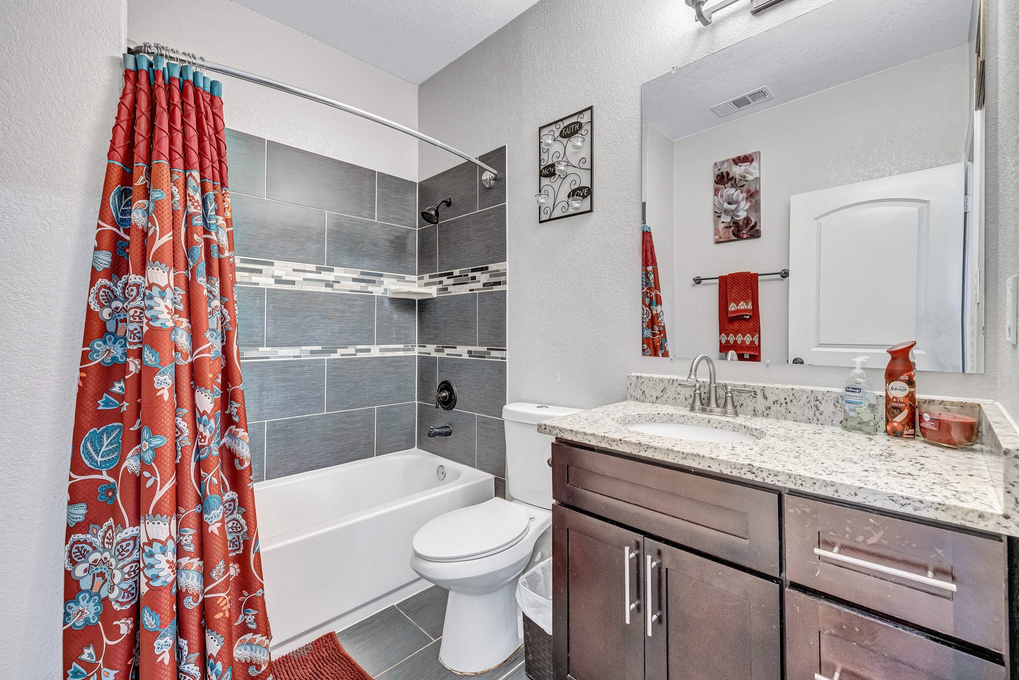 421 Las Lomas Drive Elgin, TX 78621 - Photo 18 of 30 Bathroom featuring a textured wall, vanity, shower / tub combo, and dark tile patterned floors