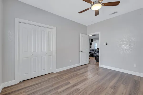 wooden floor in an empty room with a ceiling fan