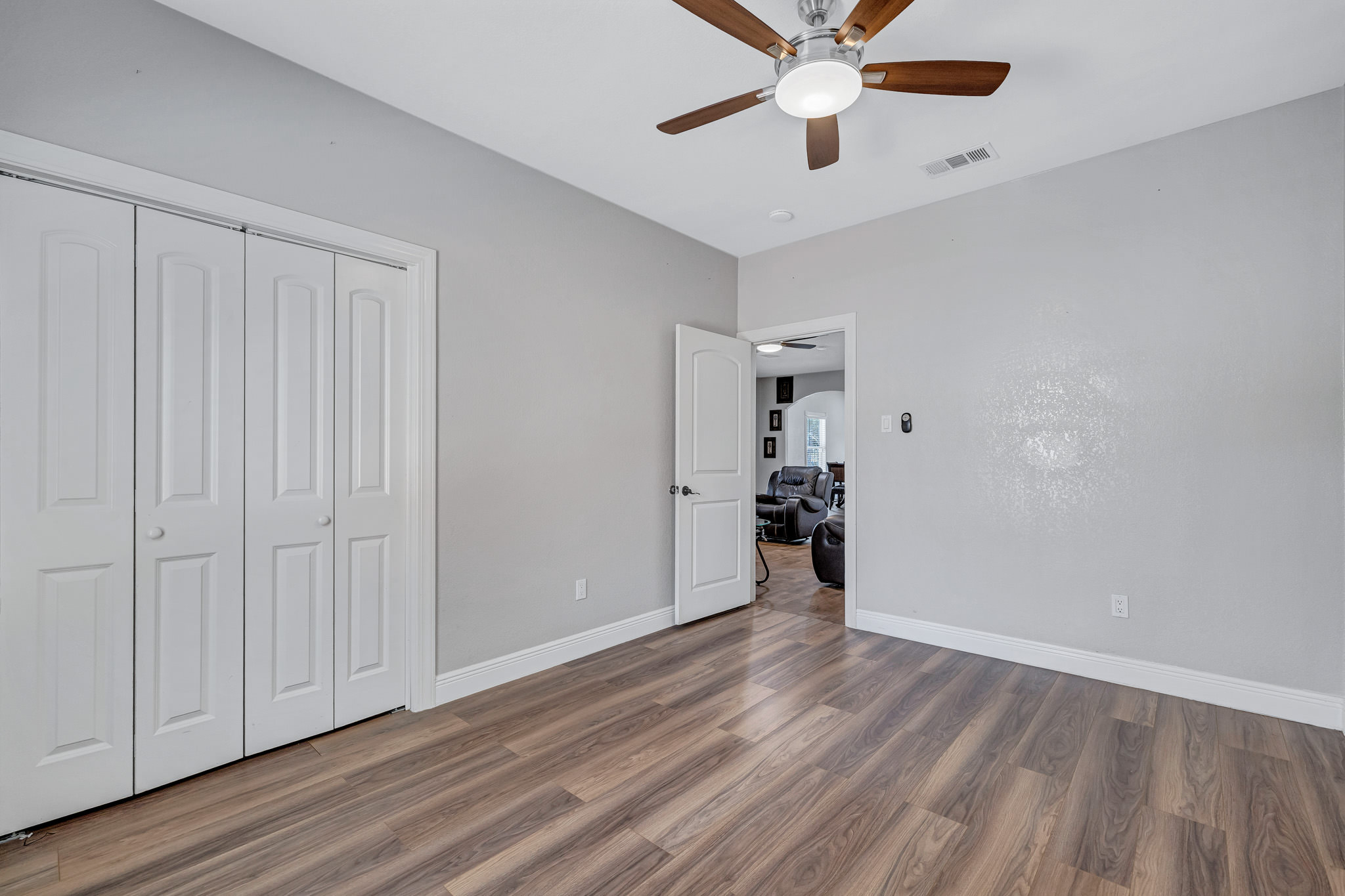421 Las Lomas Drive Elgin, TX 78621 - Photo 20 of 30 Unfurnished bedroom featuring dark wood-style flooring, ceiling fan, and a closet