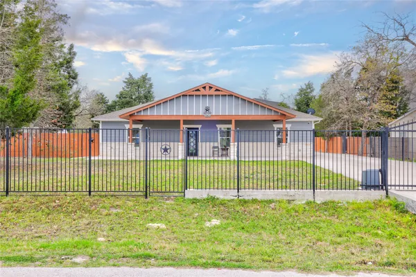 a view of a house with a wooden fence