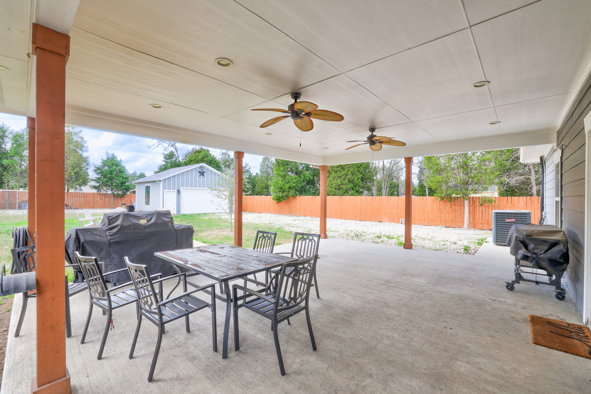 421 Las Lomas Drive Elgin, TX 78621 - Photo 23 of 30 Fenced backyard with a patio, outdoor dining area, an outbuilding, area for grilling, and a ceiling fan