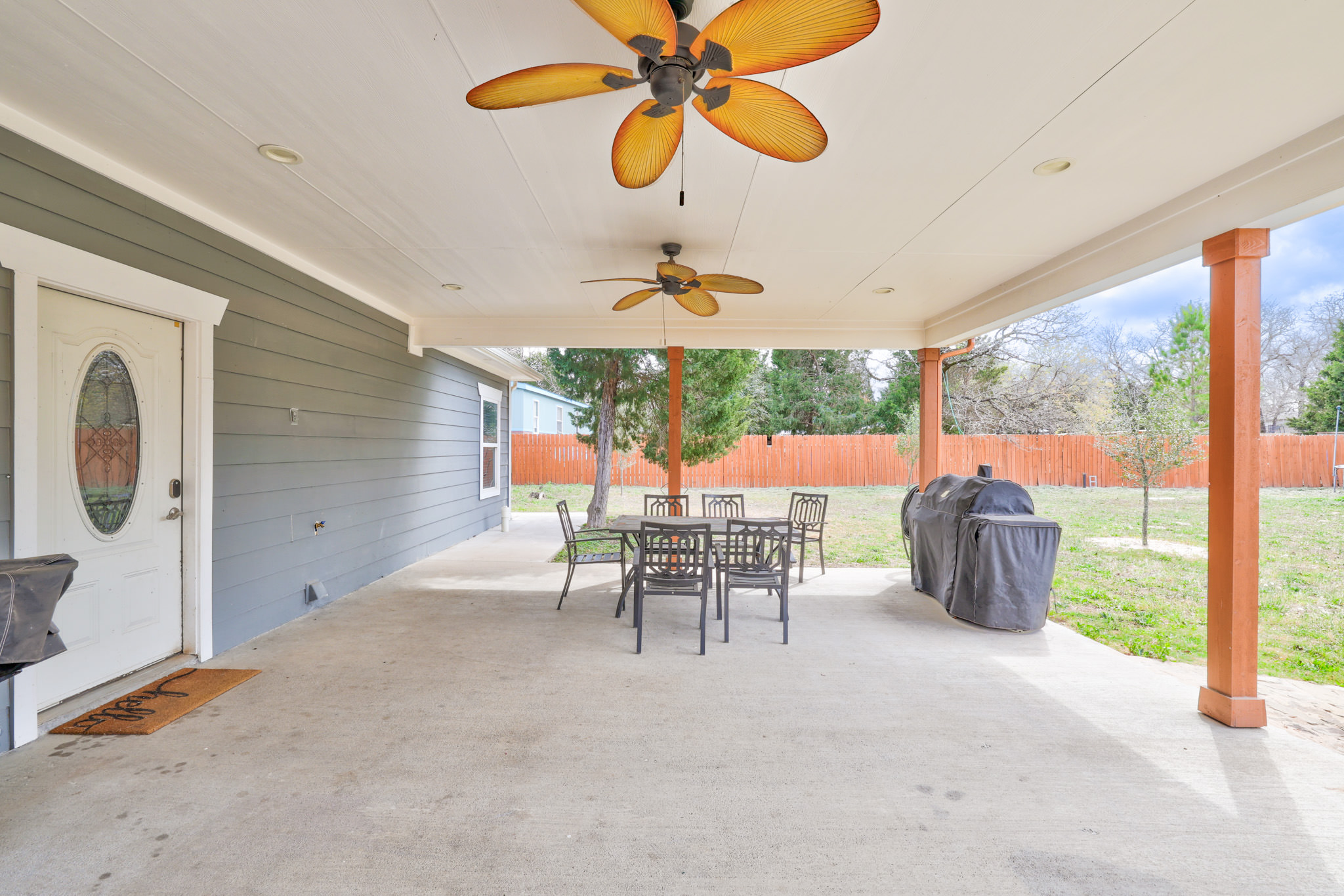 421 Las Lomas Drive Elgin, TX 78621 - Photo 24 of 30 Fenced backyard with a ceiling fan, outdoor dining area, a patio, and area for grilling