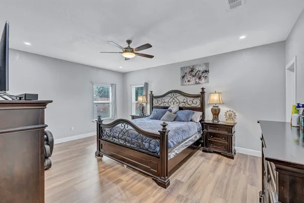 a bedroom with a bed and wooden floor