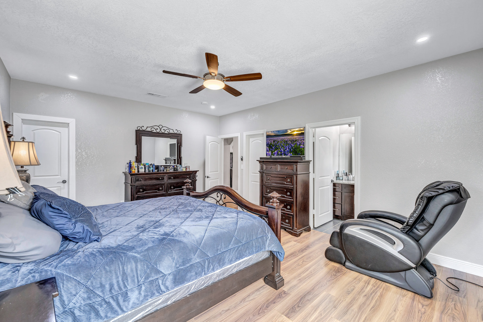 421 Las Lomas Drive Elgin, TX 78621 - Photo 10 of 30 Bedroom with light wood-type flooring, a ceiling fan, a textured ceiling, recessed lighting, and connected bathroom