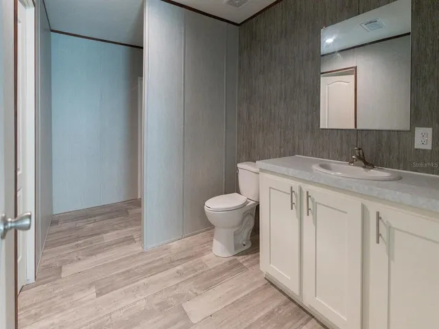 a bathroom with a granite countertop sink a toilet and a mirror