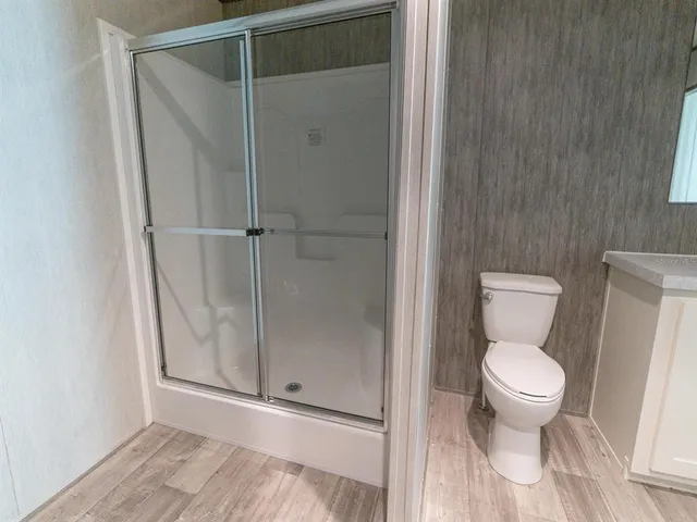 a bathroom with a toilet and a shower