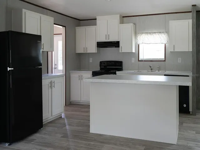 a kitchen with stainless steel appliances a refrigerator sink and microwave