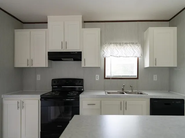 a kitchen with a sink stove and microwave